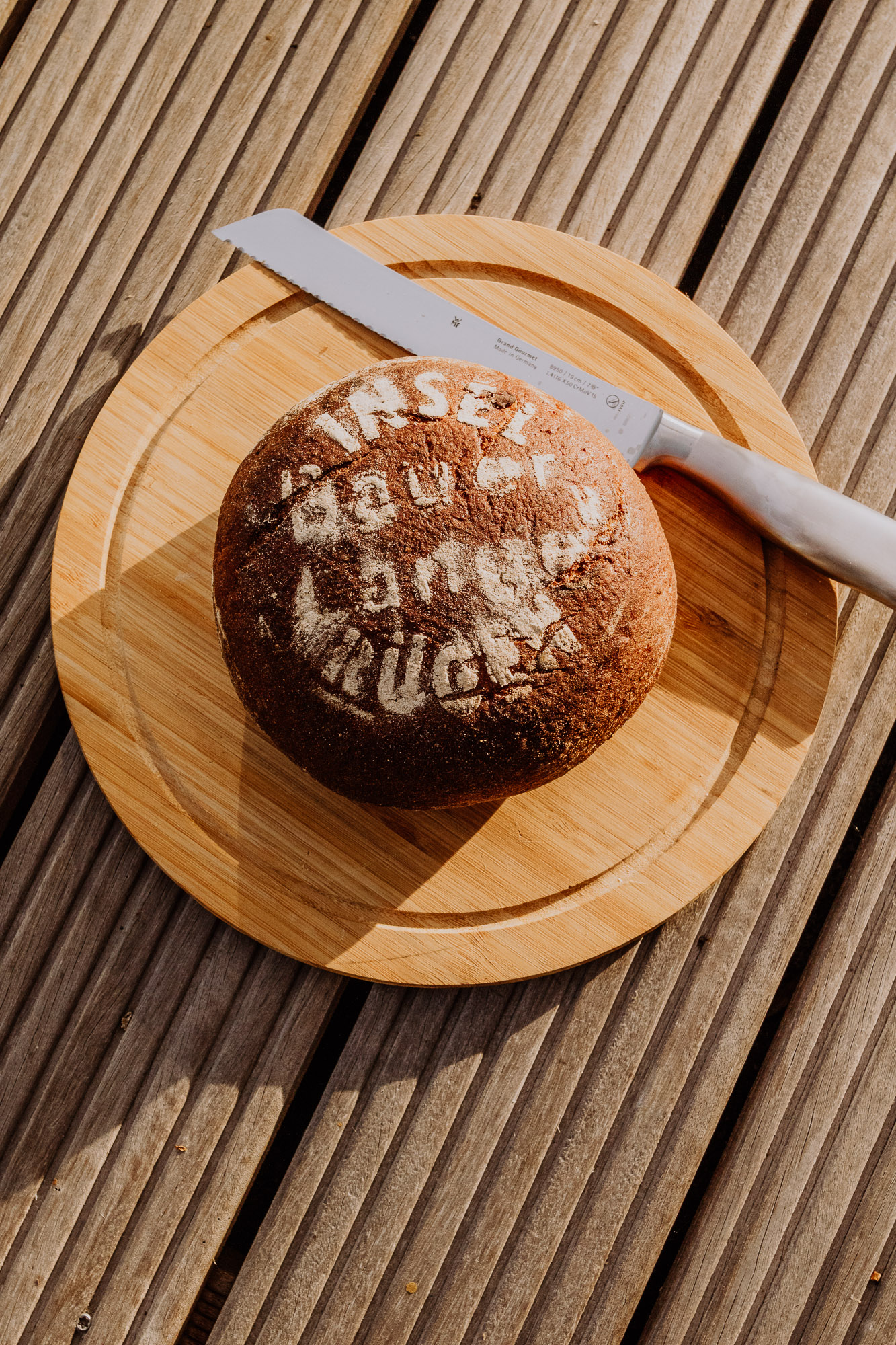 Frisches Bauernbrot vom Hofladen Bauer Lange auf Ummanz, mit dem Schriftzug ‚Bauer Lange‘ aus Mehl bestäubt