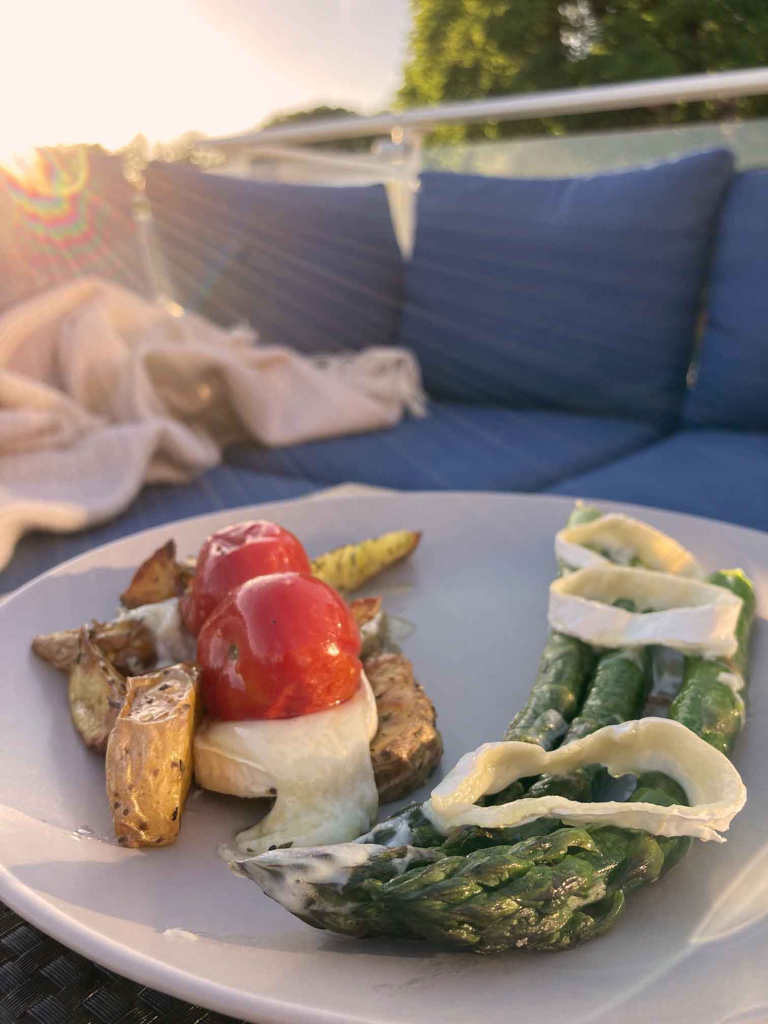 Ofengericht mit grünem Spargel, Kartoffeln, Tomaten und Ziegenkäse – serviert auf der Sonnenterrasse der Ferienwohnung FISCHER:IN auf Ummanz