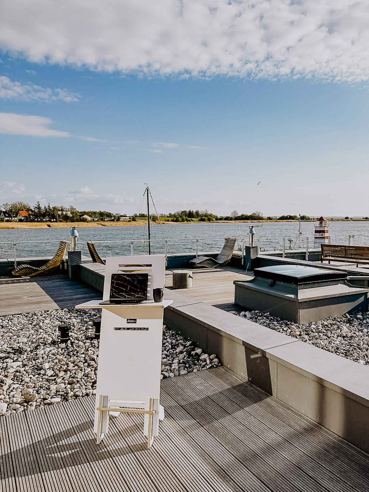 Outdoor-Workspace: Stehpult mit Laptop und Kaffeetasse auf der Terrasse der FISCHER:IN mit Panoramablick.