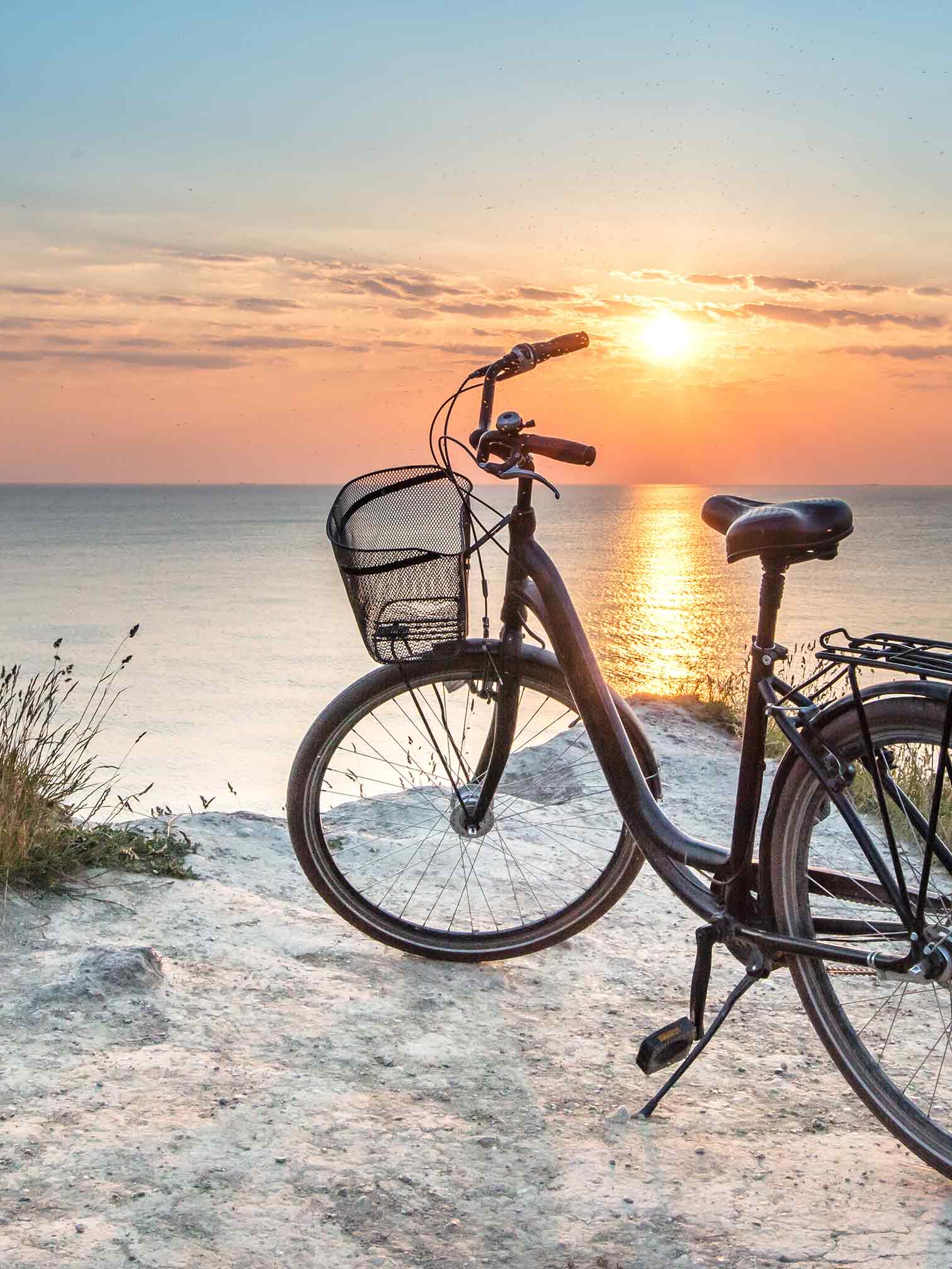 Fahrrad am Meer bei Sonnenuntergang auf der Insel Rügen – ideal für eine Radtour ab der Ferienwohnung FISCHER:IN