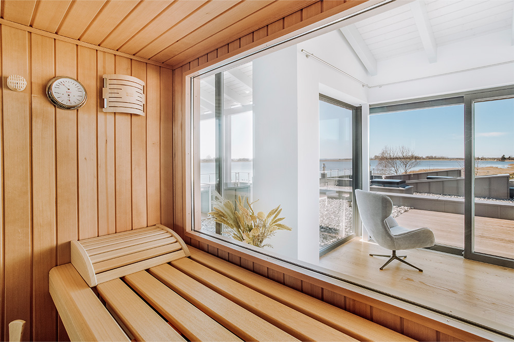 Panorama-Sauna in der Ferienwohnung FISCHER:IN auf Rügen mit Blick über die Terrasse und den Bodden